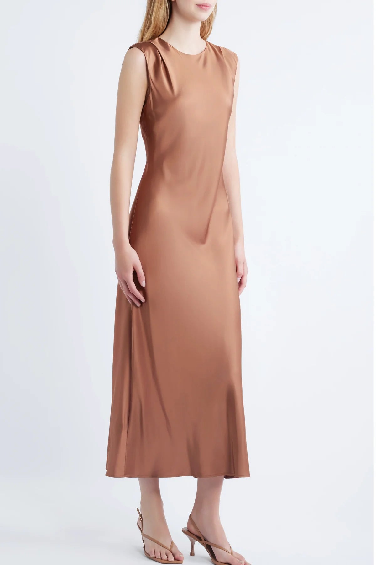 model wearing a cinnamon colored sleeveless midi dress on a white background, side