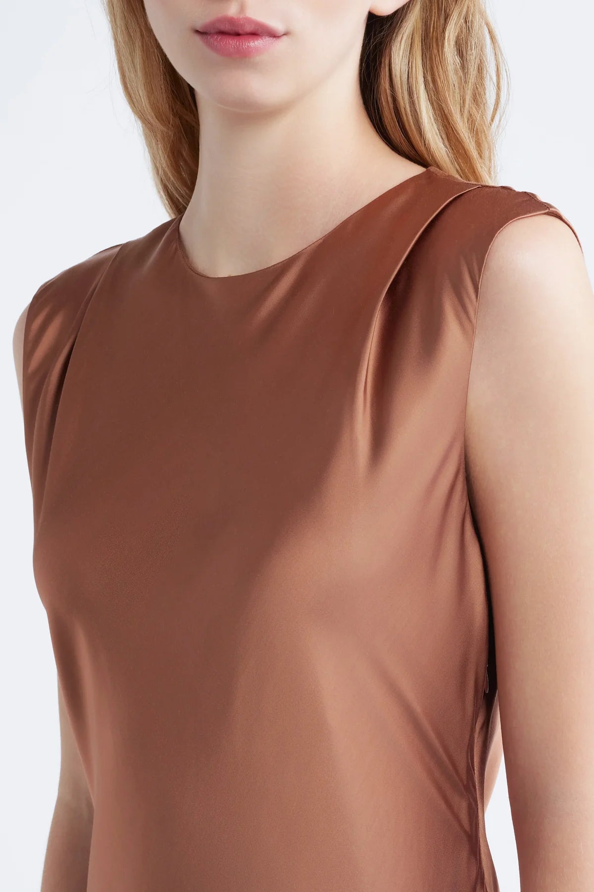 close up of shoulder pad detail on cinnamon colored dress on a model with a white background