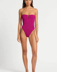 model wearing a pink one piece bathing suit on white background