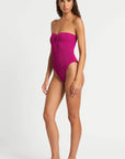 model wearing a pink one piece bathing suit on white background