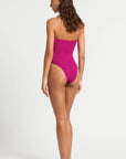 model wearing a pink one piece bathing suit on white background, back view