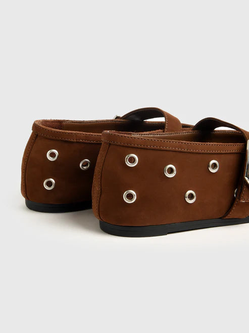 Pair of brown shoes with grommets on a light gray background