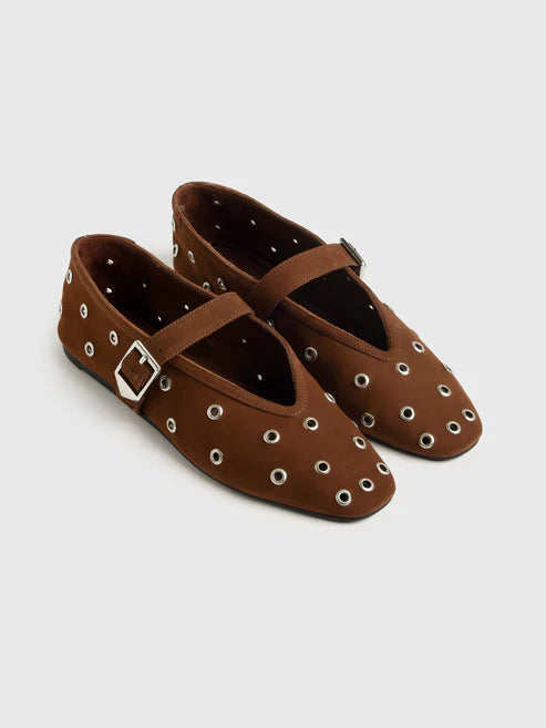Brown studded shoes with a buckle on a light gray background