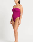 model wearing a pink one piece bathing suit on white background