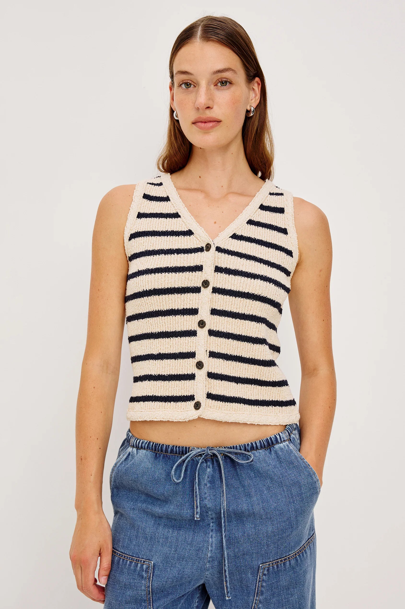 model wearing stripe vest top with denim bottoms on a white background