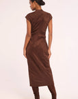 A woman shown from the back wearing a brown sleeveless midi dress with gathered side details, paired with matching brown boots, against a plain light background.