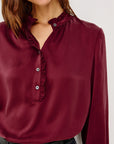 Maroon blouse with ruffled collar on a white background