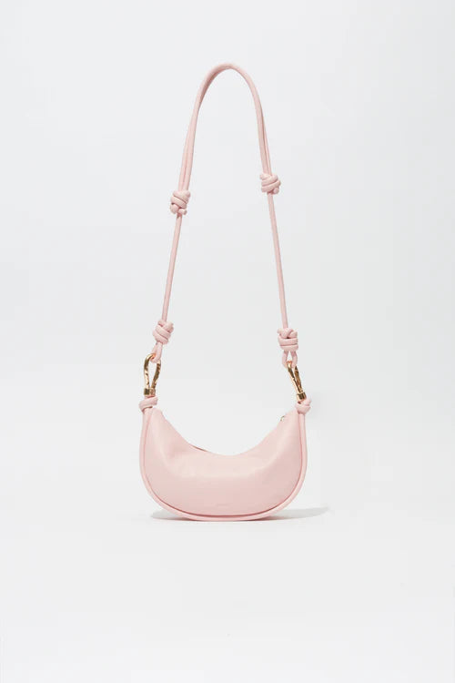 Pink handbag with a strap on a light gray background