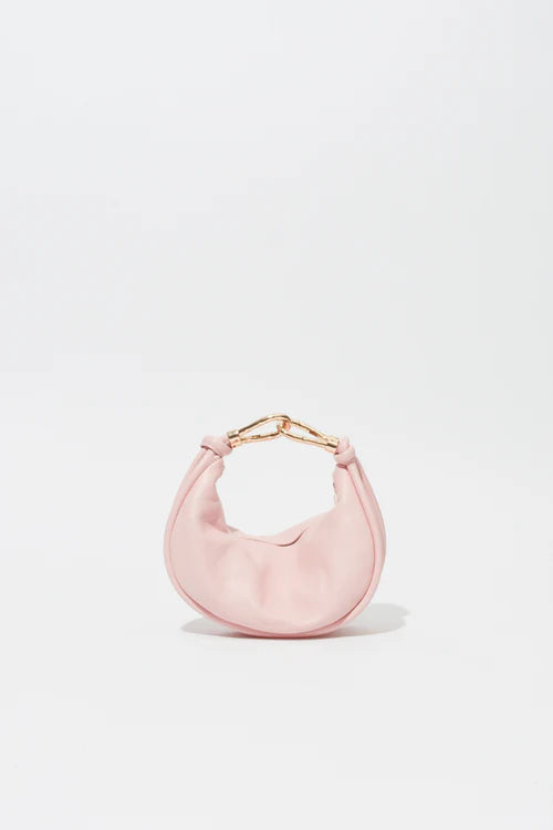 Pink handbag with gold handle on a light gray background