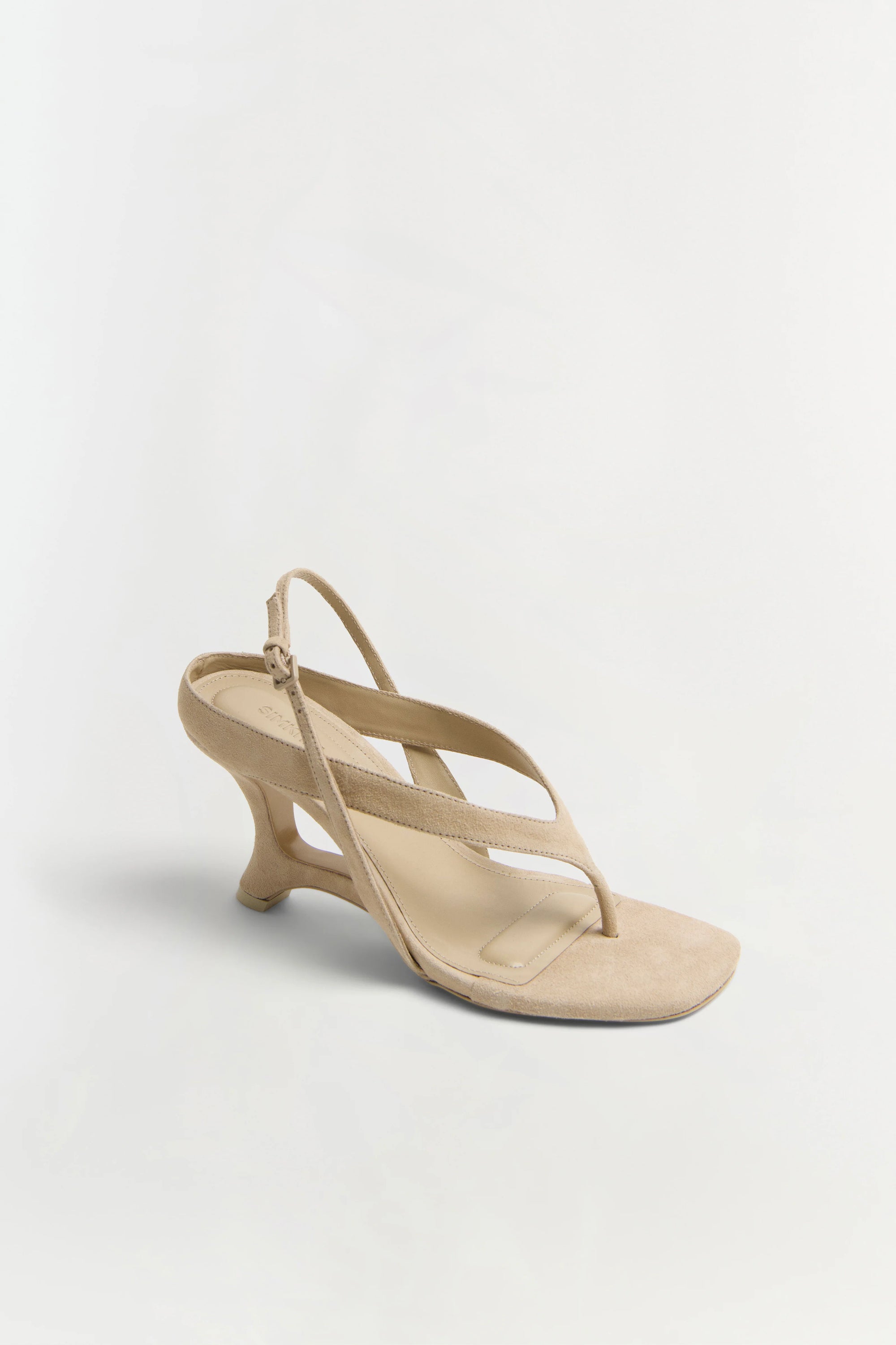 Beige sandal with a thin strap on a light gray background