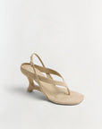 Beige sandal with a thin strap on a light gray background