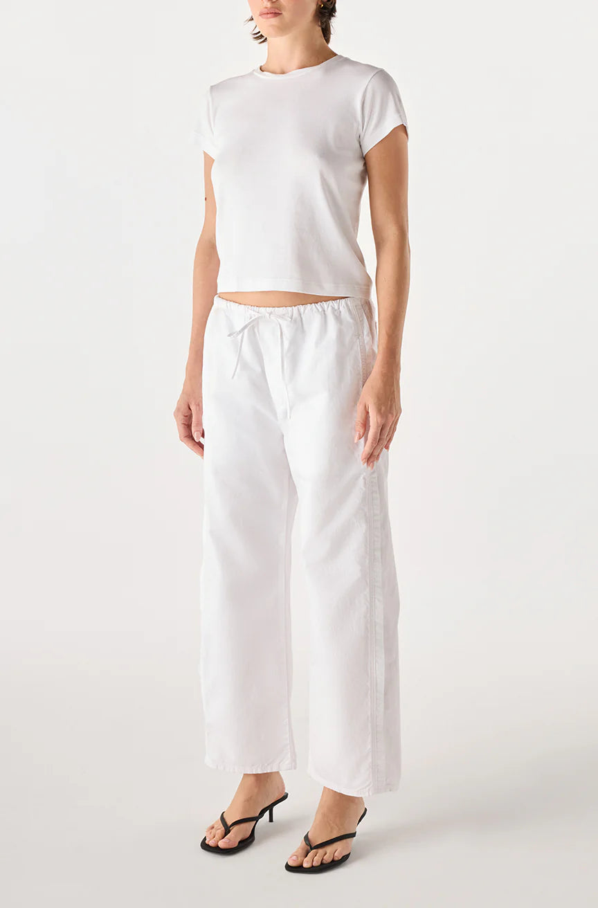 model wearing the simone white pant and a short sleeve with tee with a white background, front 
