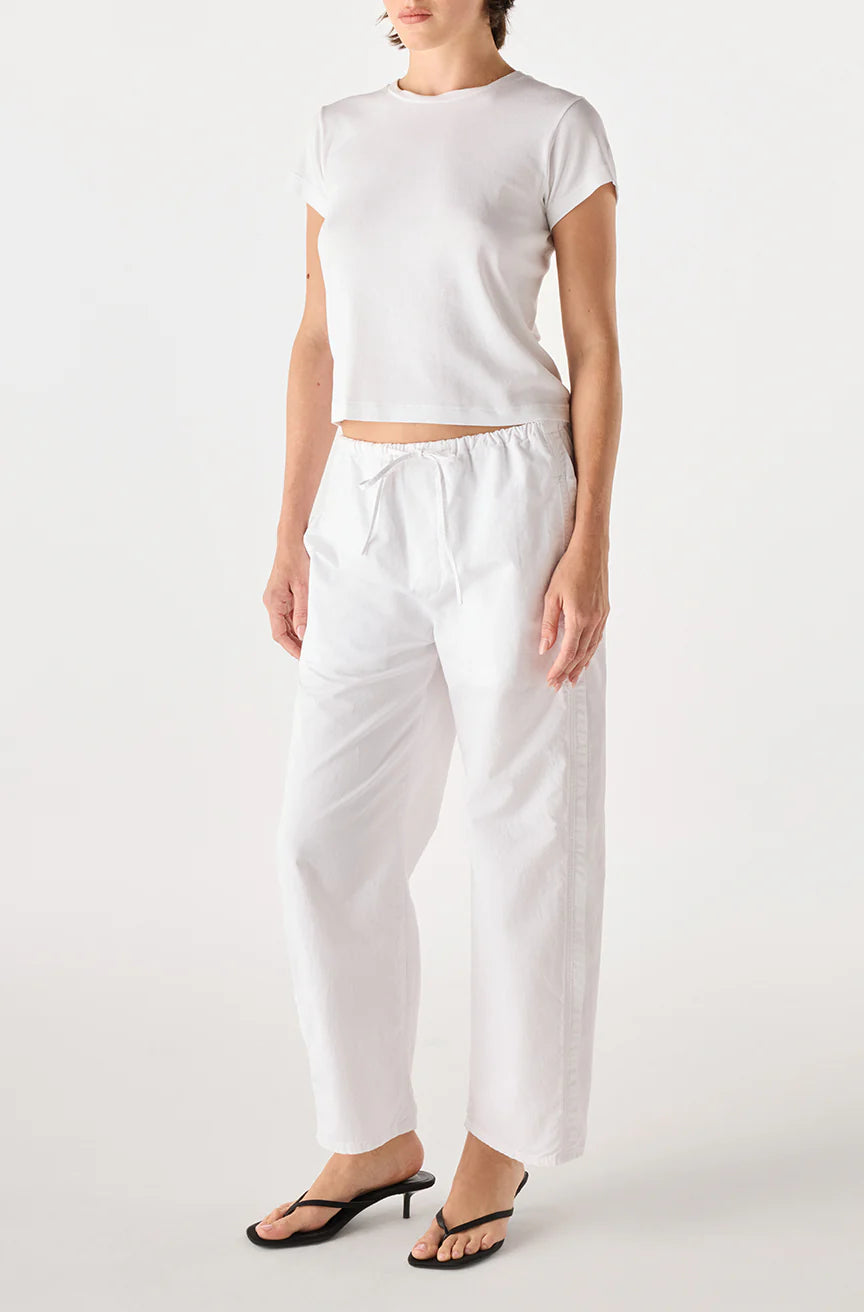 model wearing the simone white pant and a short sleeve with tee with a white background, side