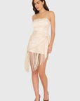 model wearing a cream colored romper with fringe scarf detail
