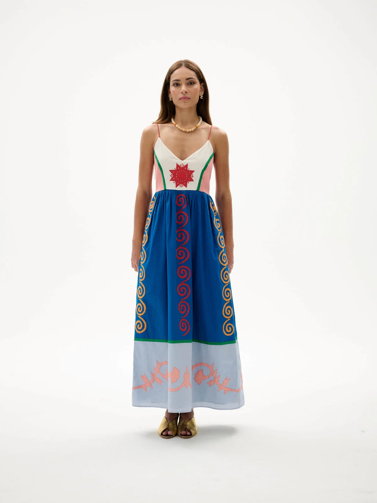 Woman wearing a colorful dress with patterns on a white background