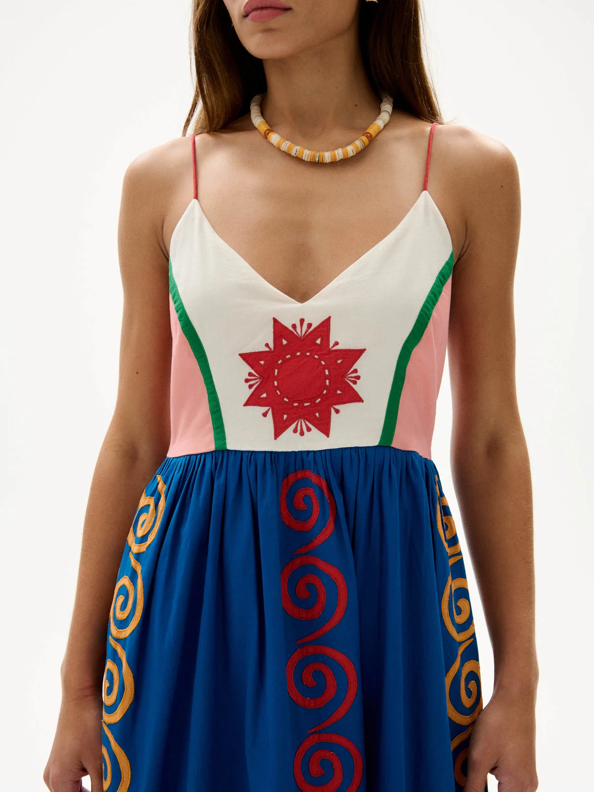 Woman wearing a dress with colorful patterns on a white background