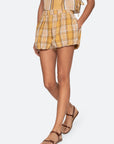 Person wearing a yellow plaid outfit on a white background