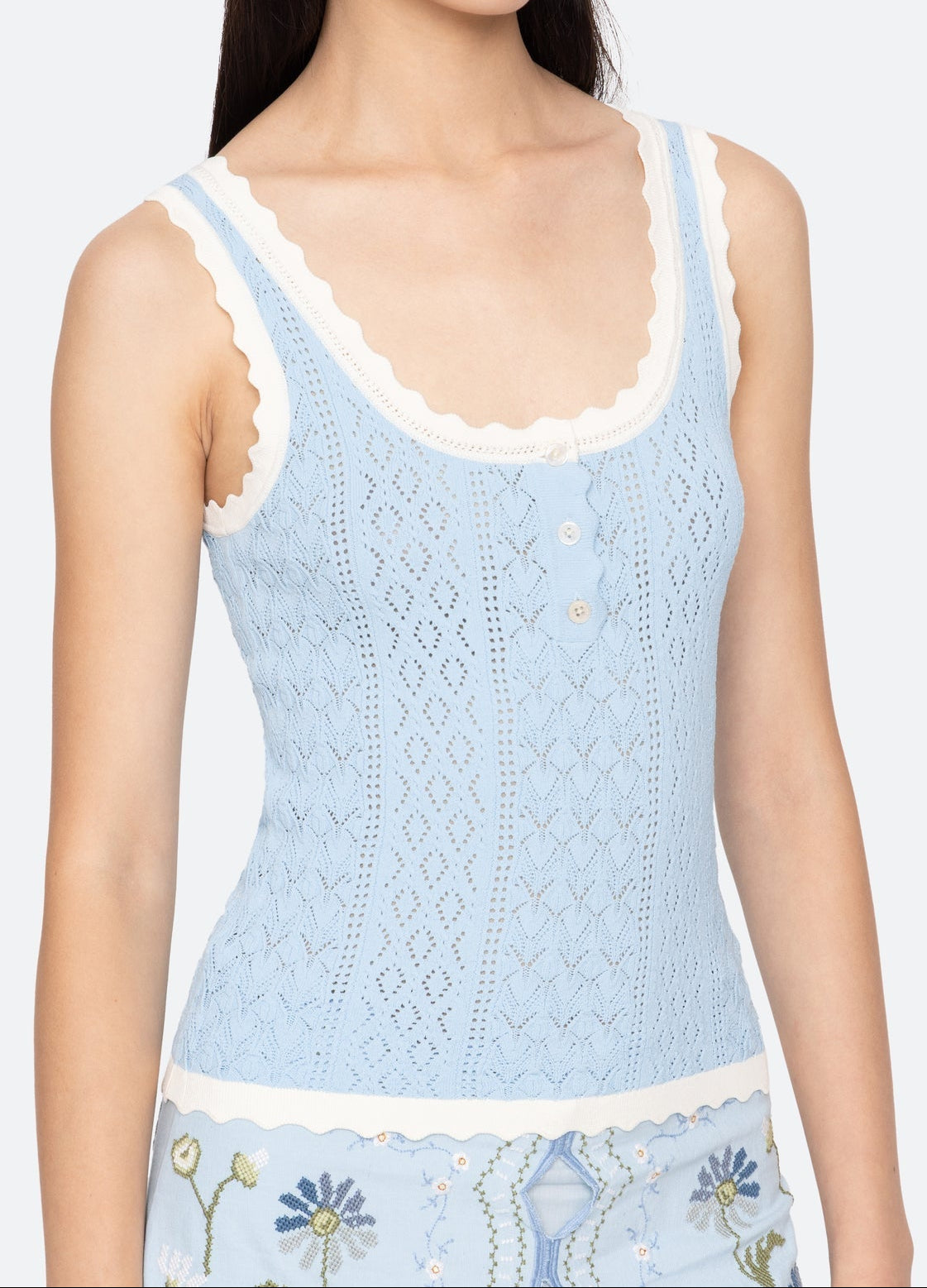 Light blue lace tank top with floral embroidery on a plain background