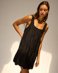 Nadia Dress front view with tilted angle of model in front of white wall