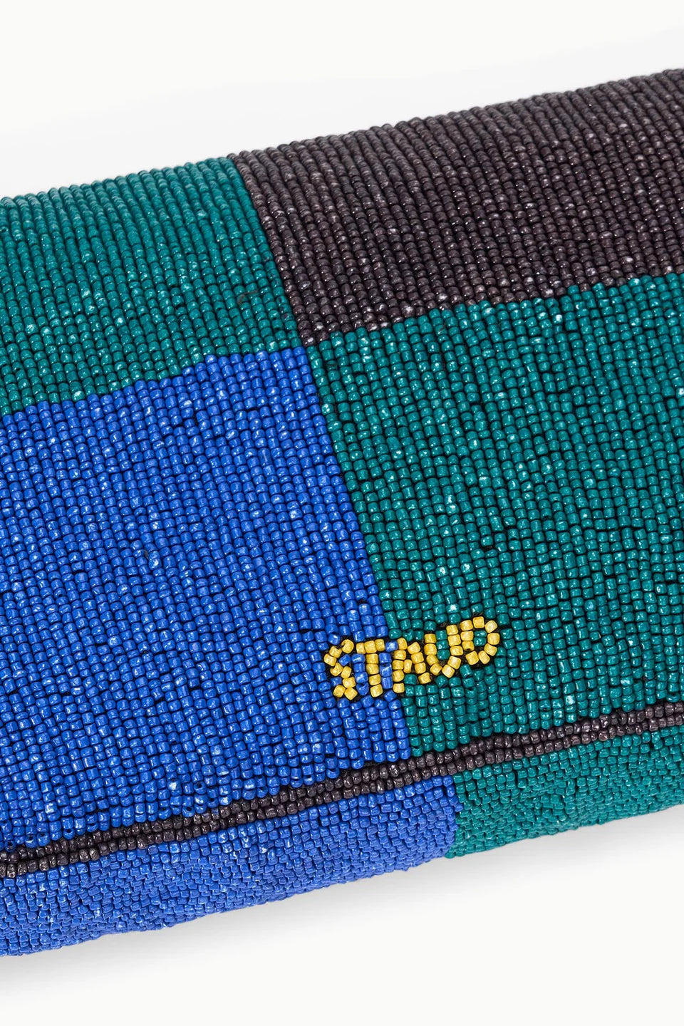 Close-up of a beaded clutch with a colorful pattern and 'Staud' branding.