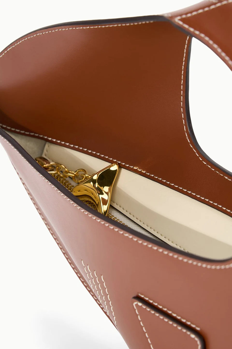 Close-up of a brown leather handbag with gold interior 