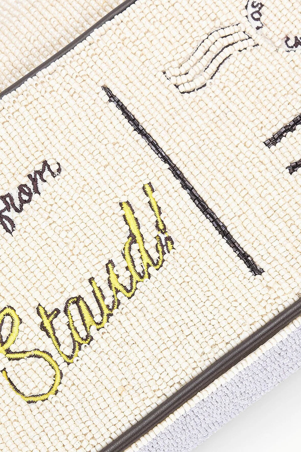 Close-up of a beaded handbag with text on fabric