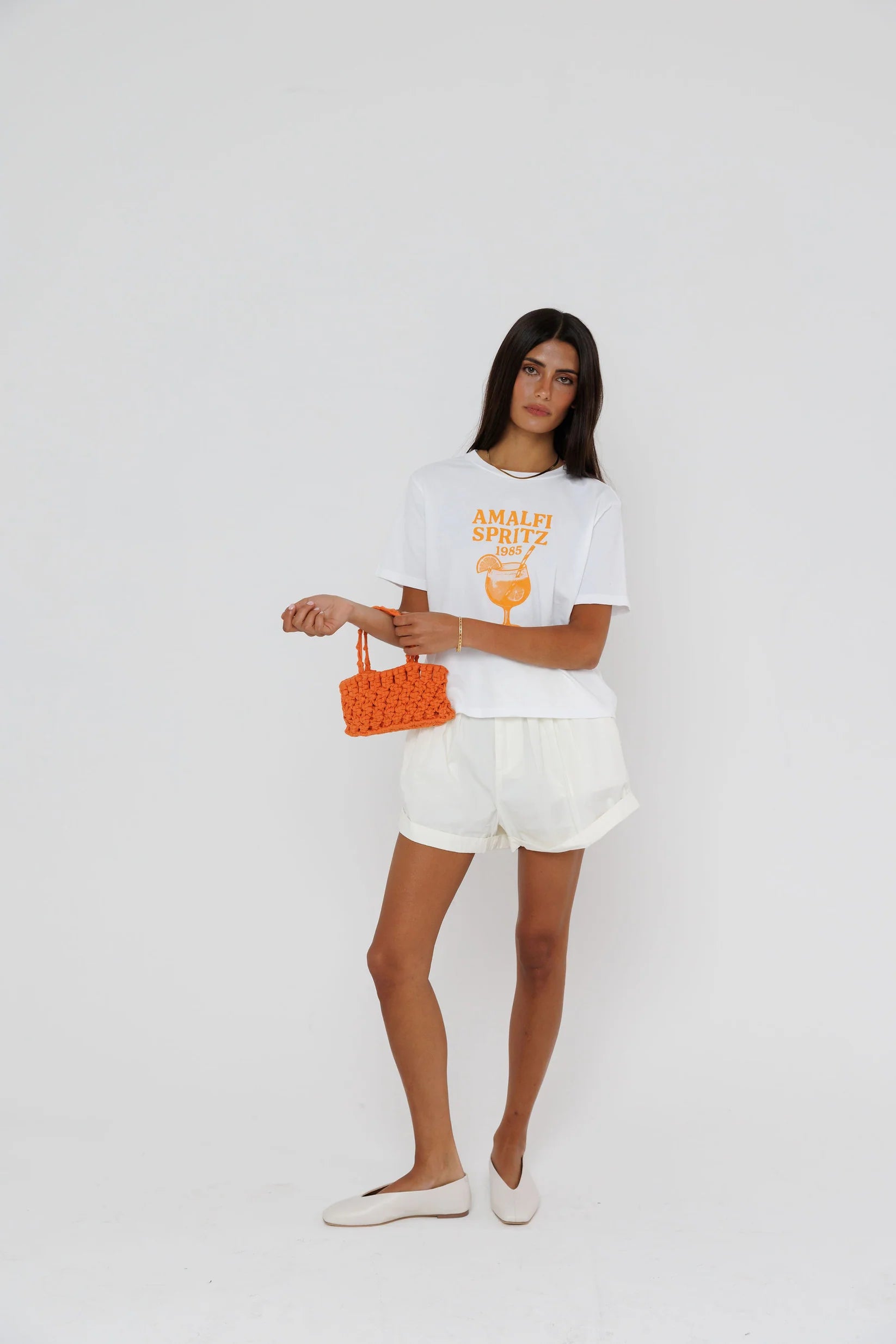 model wearing amalfi spritz short sleeve tee with white shorts on a white background