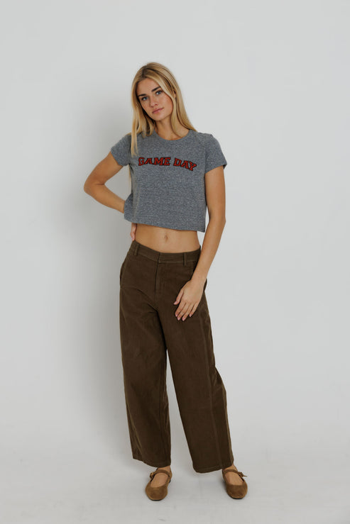 Red Game Day Tiny Tee full body front view on model with one hand on hip