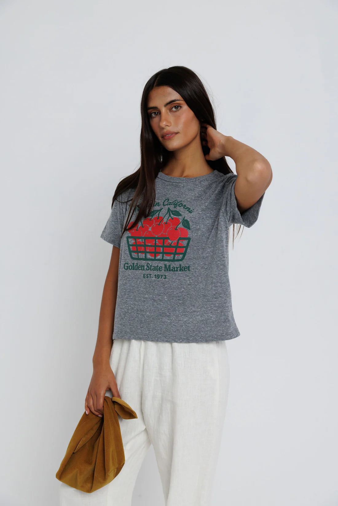 Woman wearing a gray t-shirt with a colorful graphic design on a white background