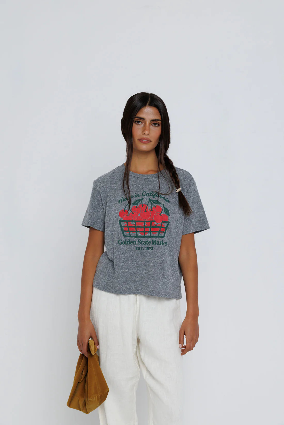 Woman wearing a gray t-shirt with a graphic design on a white background