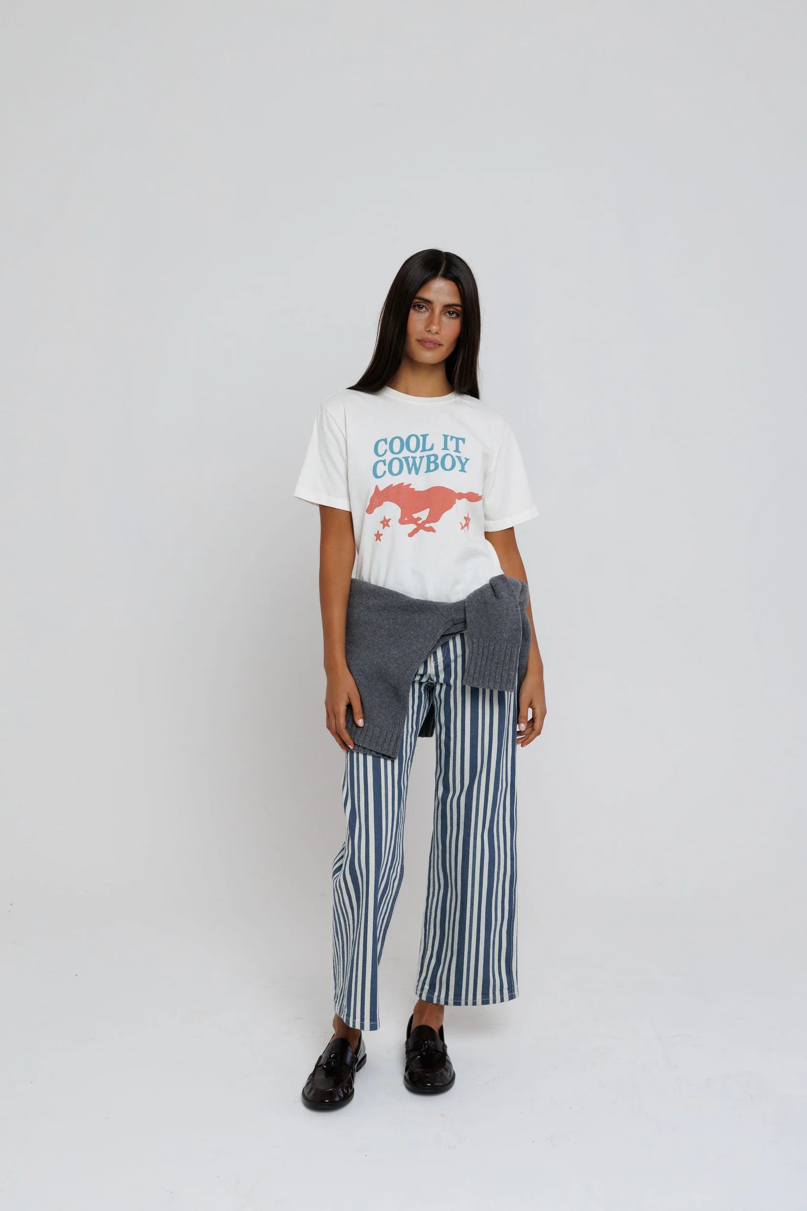 model wearing cool it cowboy tee with stripe pants on a white background
