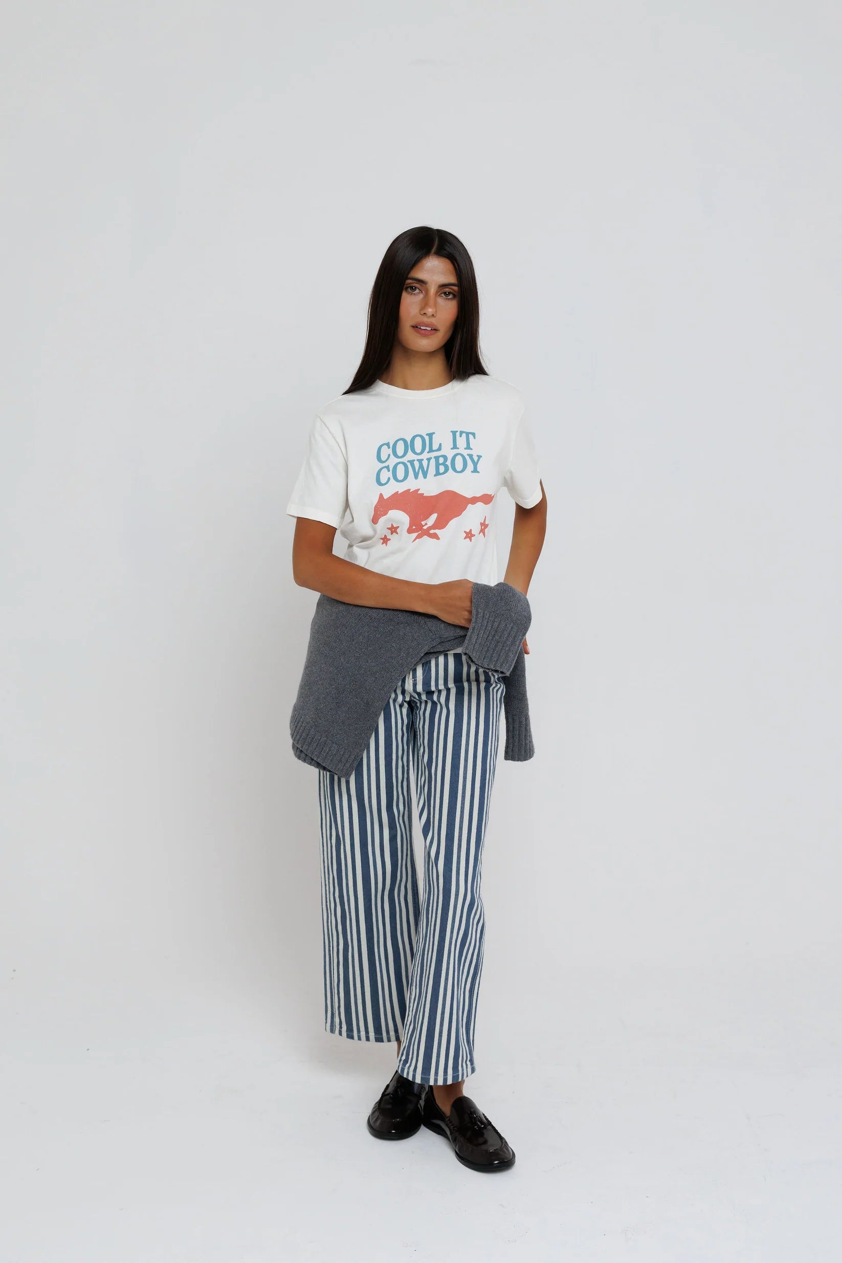 model wearing cool it cowboy tee with stripe pants on a white background