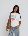 model wearing cool it cowboy tee with stripe pants on a white background