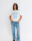 Person wearing a white t-shirt with 'pasta lover club' text and blue jeans on a white background, full body front