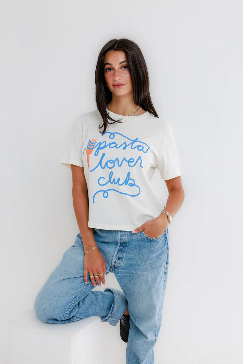 Woman wearing a 'pasta lover club' t-shirt and jeans against a white background