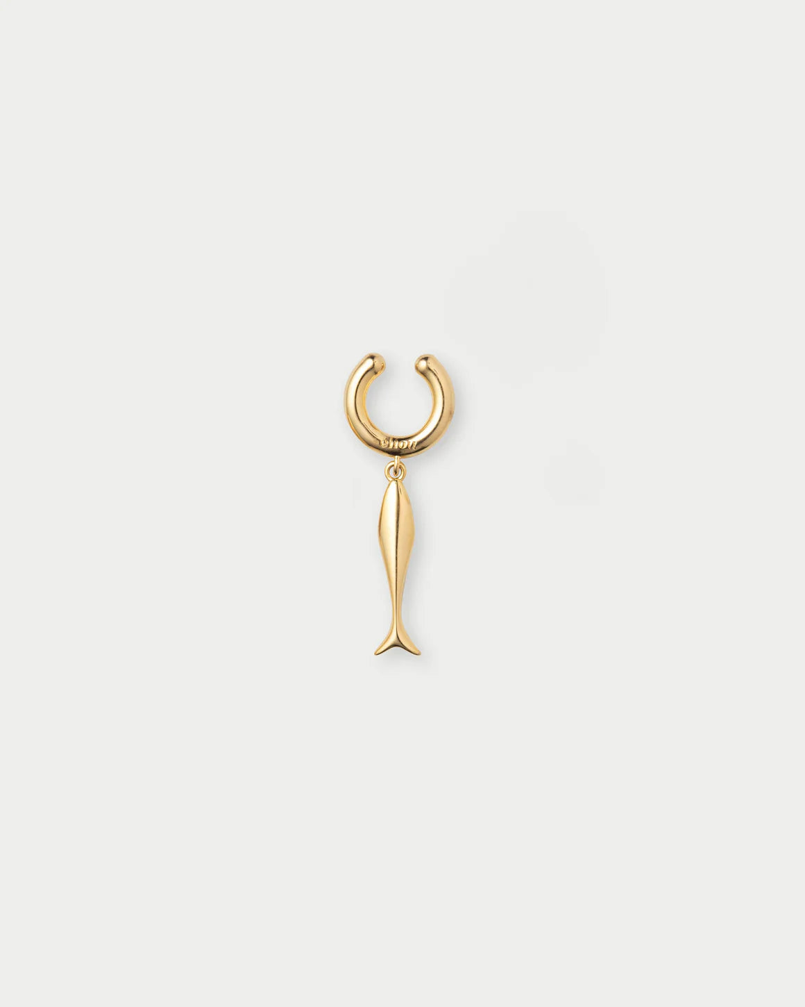 Gold fish-shaped earring on a light gray background