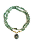 Green beaded necklace with a pendant on a white background