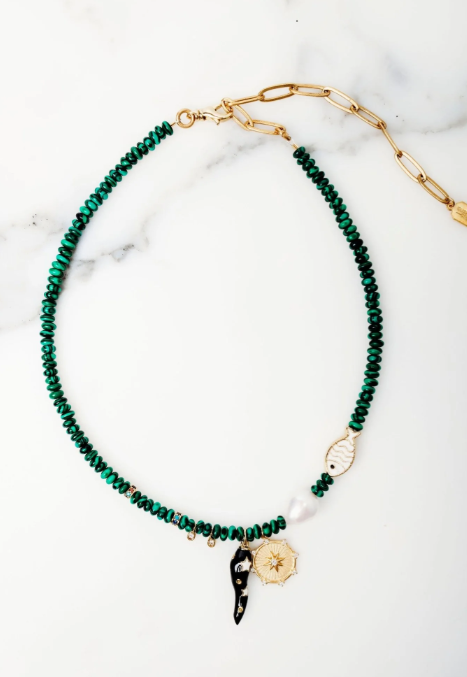 Green beaded necklace with gold chain on a white marble surface