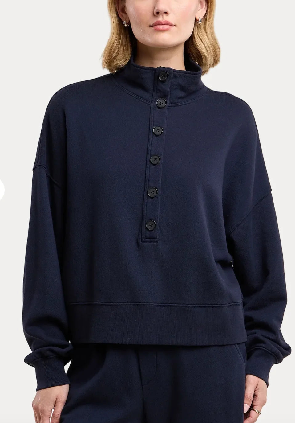 model wearing a navy sweatshirt on a white background 