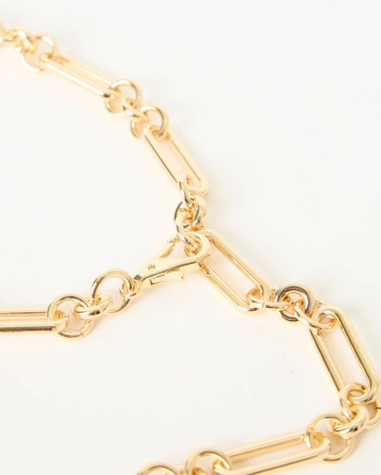 Gold chain belt on a light beige background