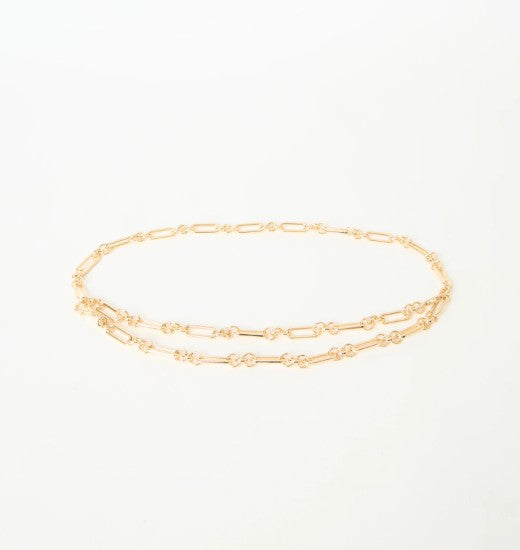 Gold chain belt on a light beige background