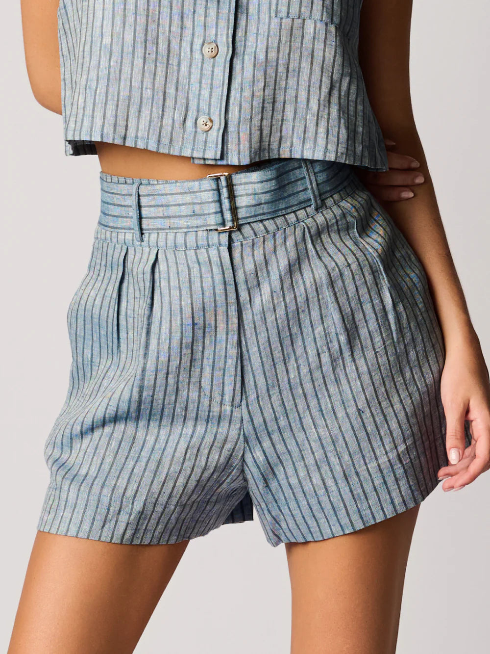 Person wearing blue striped shorts and a matching top on a plain background