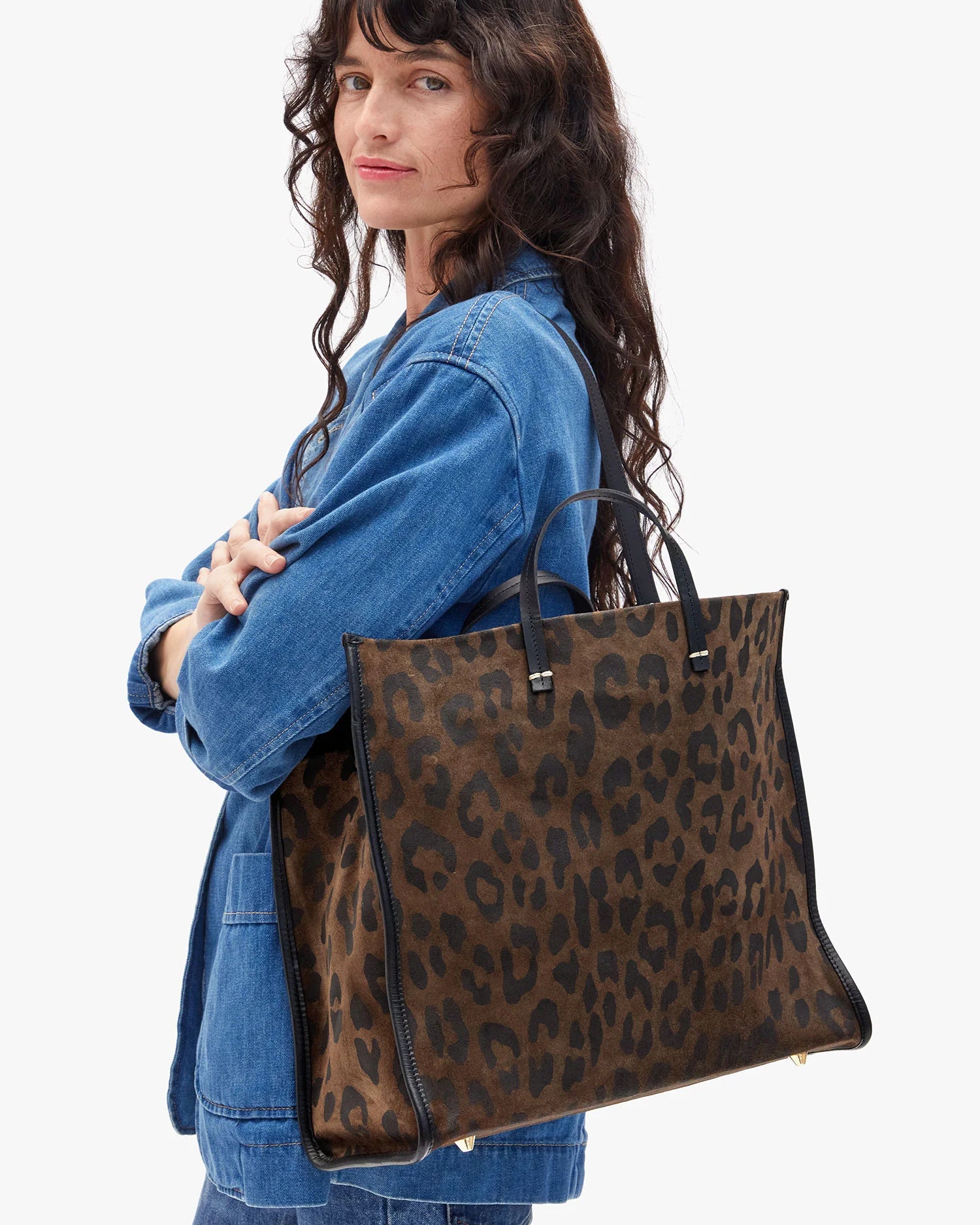 Woman carrying a leopard print tote bag on a white background