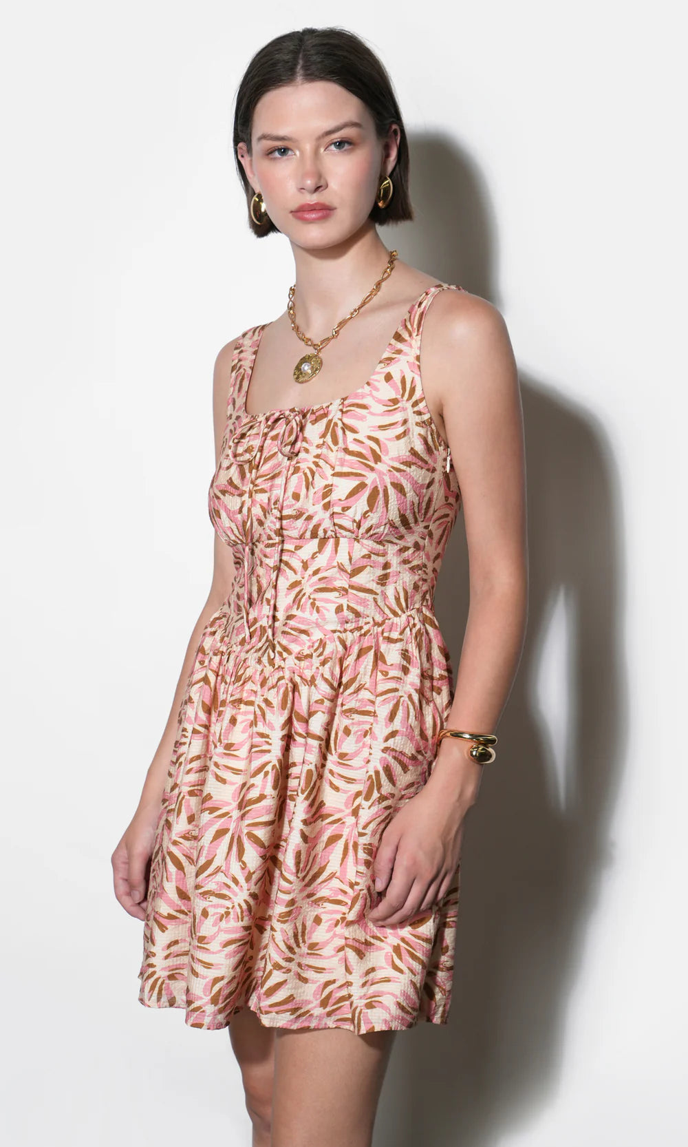 Woman wearing a patterned dress against a white background