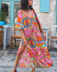 Woman wearing a colorful dress with floral patterns in an outdoor setting.