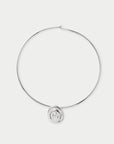 A minimalist silver-toned wire hoop necklace with a small circular spiral pendant at the bottom center, displayed on a clean light gray background.