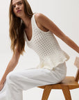 Anna Peplum Sweater Tank side view, model on stool