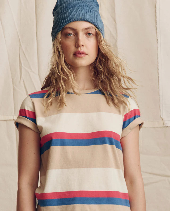 Person wearing a striped shirt and blue beanie against a neutral background