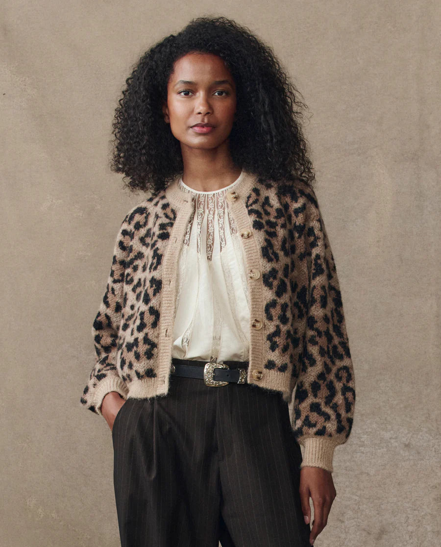 model wearing the leopard windsor cardigan with a cream top and jeans cream background, front