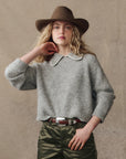 grey cardigan on a model with green pants and a western hat on a cream background, front